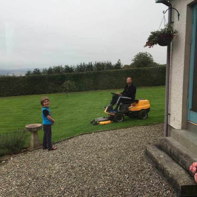 Dad on the lawnmower at our second housesit, Culbokie Scotland