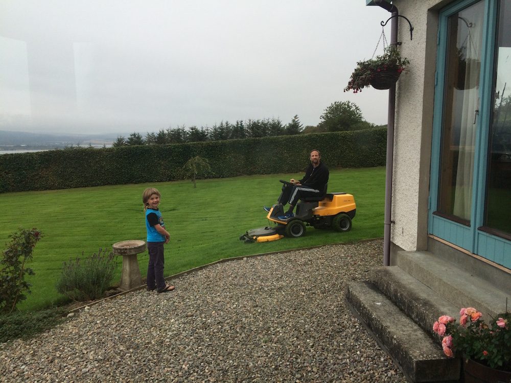 Nathaniel riding the lawn mower at the Scotland housesit