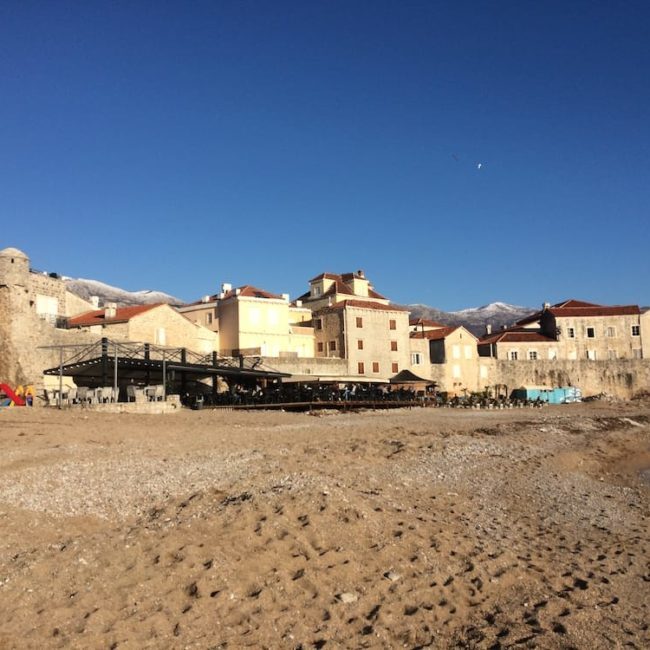 Looking back at the Old Town Budva cafes from the beach pier