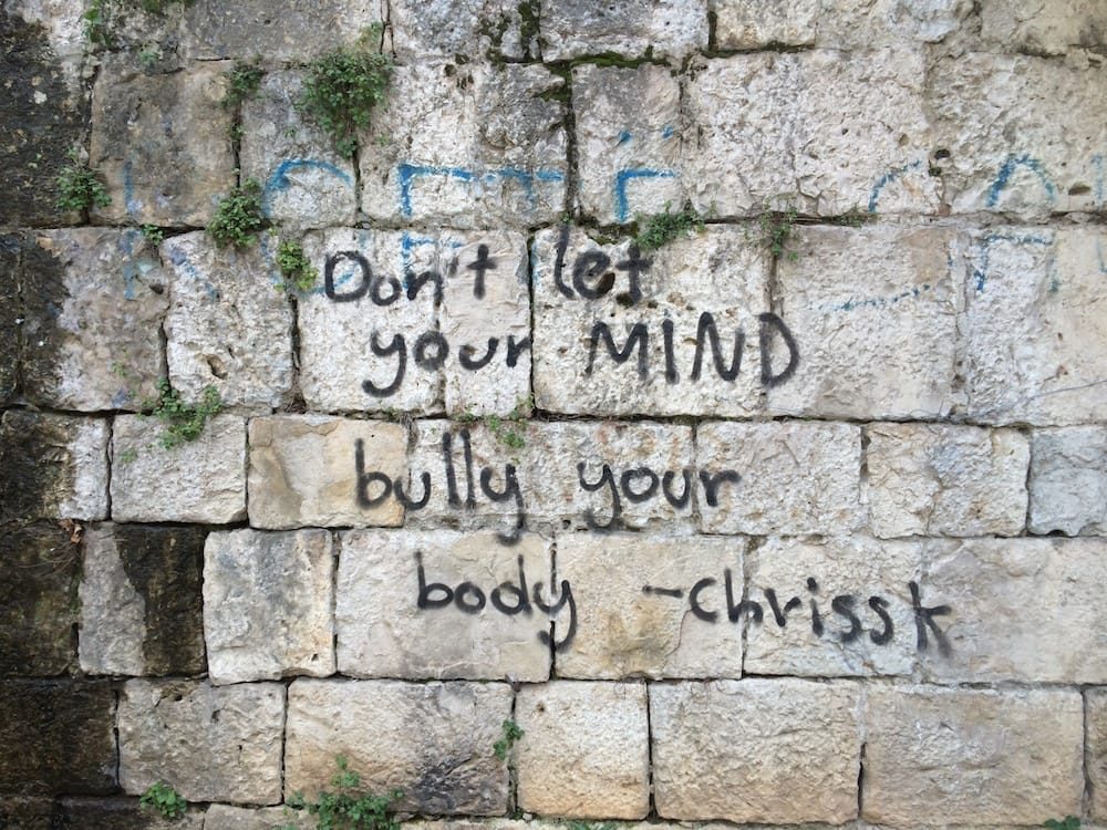 Don't let your mind bully your body, sage advice painted on this wall